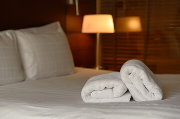 Fototapeta na wymiar Clean white towel set on bed in hotel bedroom, relax, holiday, vacation concept.