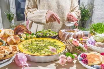 Festive dinner, Easter brunch. Traditional Easter dishes on family home table - baked meat, quiche, spring salad, muffin, colored eggs, hot cross buns