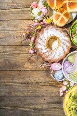 Festive dinner, Easter brunch. Traditional Easter dishes on family home table - baked meat, quiche, spring salad, muffin, colored eggs, hot cross buns