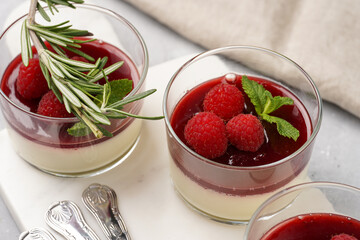 Italian dairy dessert panna cotta with raspberry jam, fresh raspberries and mint on marble board