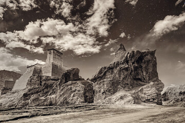 Ruins and Basgo Monastery surrounded with stones and rocks , sky with clouds in the background, Himalayan Mountain range, Leh, Ladakh, Jammu and Kashmir, India - tinted image of Indian monasteries