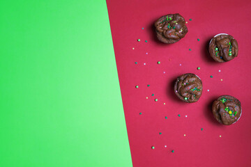Delicious cupcake with sprinkles on a red and green background. New Year and Christmas background 2022 - 2023.