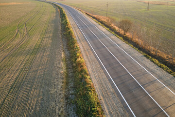 Aerial view of empty intercity road at sunset. Top view from drone of highway in evening