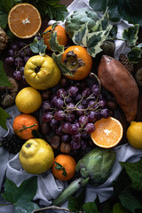 
Still life with autumn and winter fruits. Light dark still life with fruits and green leaves. Baroque style still life