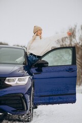 Woman sitting in her new car in a winter park