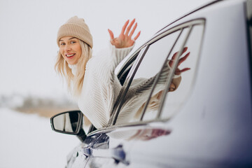 Woman sitting in her new car in a winter park