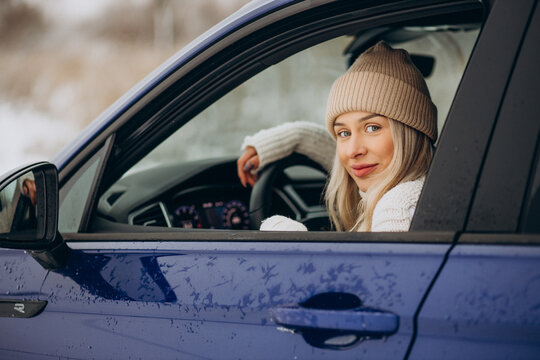 Woman sitting in her new car in a winter park