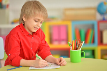 Portrait of cute little boy drawing