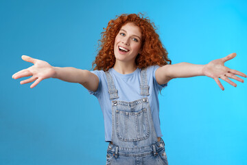 Friendly cheerful family-oriented stylish charming redhead curly-haired girl extend arms embraces wanna cuddle smiling tender tilt head grin inviting girlfriend warm hugs stand blue background - obrazy, fototapety, plakaty