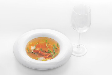 Restaurant serving of soup 2 - vegetables and slices of white fish,  Green asparagus, carrots and red bell peppers. An empty glass is near. Insulated Food Plate