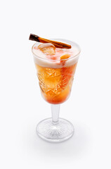 Cocktail in a tall glass transparent glass - orange colored drink with fruit orange,  brown cinnamon sticks and foam top. Diet delicious drink, healthy food, isolated