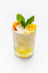 Cocktail in a simple glass - yellow colored drink with fruit orange and green mint leaves. Diet delicious drink, healthy food, isolated