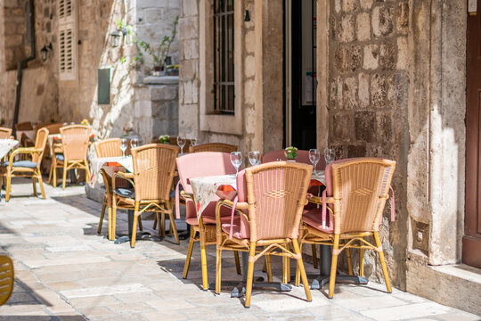 Fototapeta Table and chairs at the restaurant in narrow street are prepared for guests and tourist. Old city of Dubrovnik, Croatia.