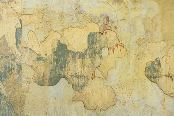 Wall murals Old dirty textured wall Old cracked weathered painted wall background texture. Yellow dirty peeled plaster wall with falling off flakes of paint