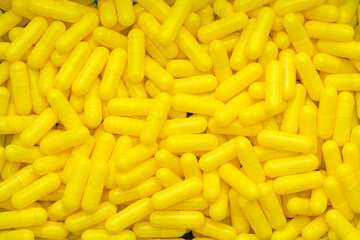 A bunch of yellow capsules. Multiple medicines. Many drugs. Illustration for a pharmacy or covid. 3D rendering