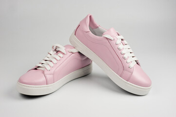 Light pink faux leather shoes laced with laces. Close-up shot.
