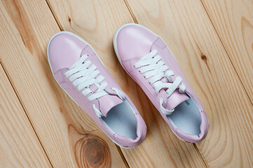 Light pink faux leather shoes laced with laces. Close-up shot.