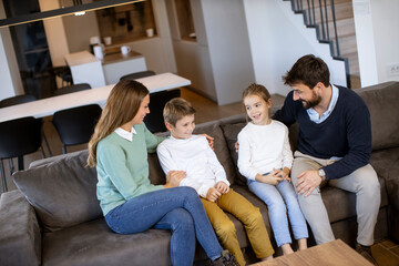 Young family watching TV together on the sofa in the living room