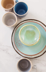Obraz na płótnie Canvas ceramic cups and plates on white marble table