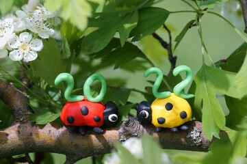 Figurines of two ladybirds made of plasticine. At the top is the calendar date 2022.
