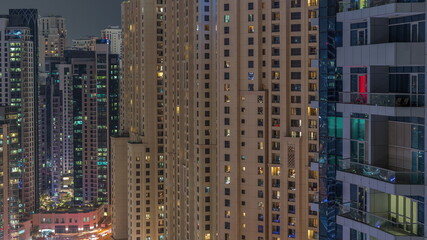 Overview to JBR and Dubai Marina skyline with modern high rise skyscrapers waterfront living apartments aerial night timelapse