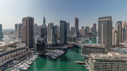 Panorama showing aerial view to Dubai marina skyscrapers around canal with floating boats timelapse