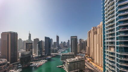 Fototapeta na wymiar Aerial view to Dubai marina skyscrapers around canal with floating boats all day timelapse