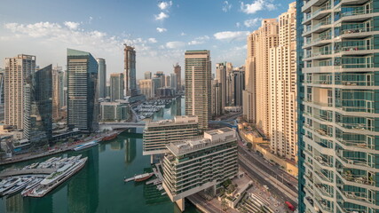 Aerial view to Dubai marina skyscrapers around canal with floating boats timelapse