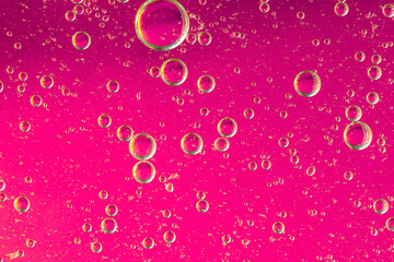 Oil with bubbles on coral background. Pink Abstract space background. Soft selective focus. macro...