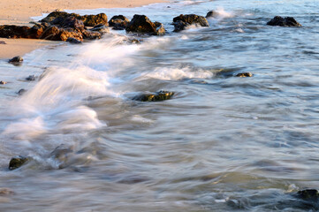 waves flowing on the rocks of a shallow water beach