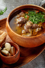 Beef goulage with garlic and pita bread and cutlery on a gray stone table