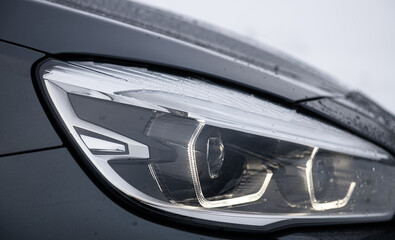 Fototapeta na wymiar Detail close up view of the LED adaptive head light of premium luxury sedan car. Automotive lighting technology detail.