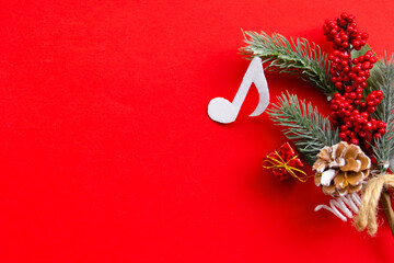 Composition with notes and christmas decorations on red background. Christmas music concept