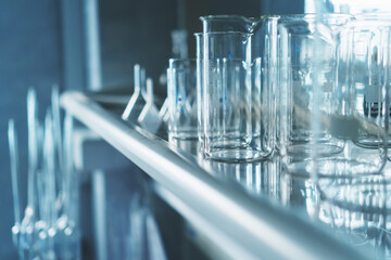 Laboratory flasks in a row on a shelf in the laboratory.