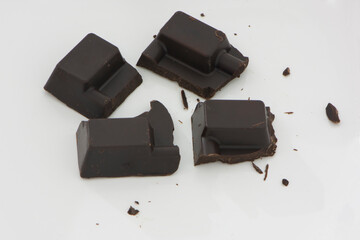 Four cubes of dark healthy chocolate on the white background