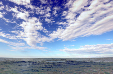 Obraz premium large background ideal as a backdrop with the sea and the blue sky with white clouds