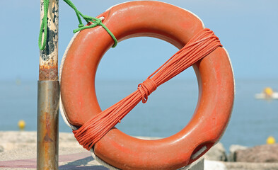 orange lifebuoy available to swimmers on the ocean shore