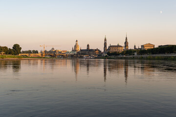 Fototapeta na wymiar Cityscape of the historic old town in Dresden with reflections in the Elbe river. Beautiful city in Saxony in the evening sunlight. The famous buildings forming the skyline