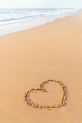 heart shape on the sandy beach, valentine's day, vertical image, and copy space.