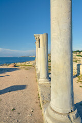 Columns of an ancient Greek temple against the background of the sea.