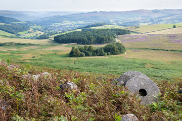 Abandoned millstones on a hill overlooking moorland, Peak District, UK
