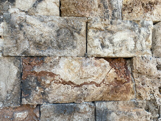 An ancient stone wall made of stones and hewn blocks