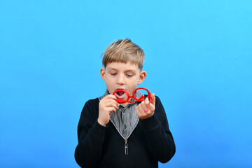 The boy wipes his red glasses in which there are no glasses, stupid boy.