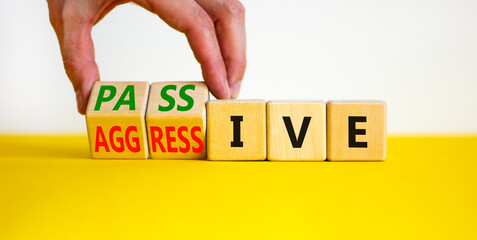 Passive or aggressive symbol. Businessman turns wooden cubes and changes the word passive to aggressive. Beautiful white background, copy space. Business, psychological passive aggressive concept.