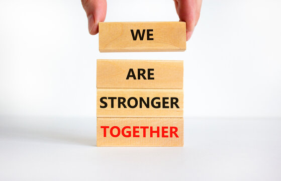 We are stronger together symbol. Concept words We are stronger together on wooden blocks. Businessman hand. Beautiful white background, copy space. Business and we are stronger together concept.