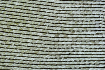 Shingle wooden tile facade background. Texture of old weathered wooden tiled roof or the floor of old wooden boards. Eco background. Environmental conservation, eco-friendly house concept