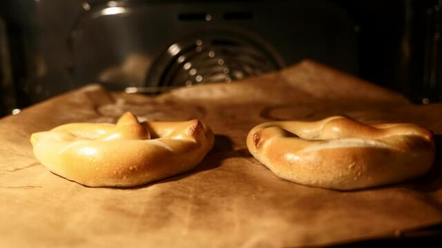Frische Laugenbrezen beim Aufbacken im Ofen. Timelapse von Teiglich zum goldbraunen Geb&auml;ck.