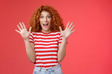 Extremely wonderful news she excited. Thrilled emotive gorgeous redhead woman scream amazed awesome surprise raise hands waving impressed open mouth stare charmed fascinated red background