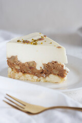 A piece of cake is on a saucer on the table. This is a cake with walnuts.
