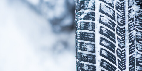Closeup view of winter tires on a road covered with snow in cold freeze winter months.